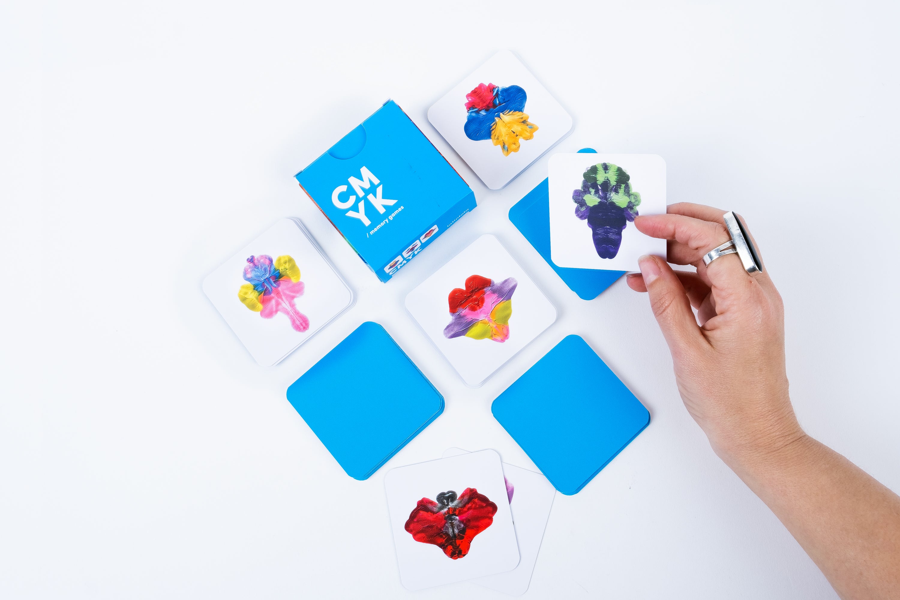 Colorful card game with hand holding a card on a white background